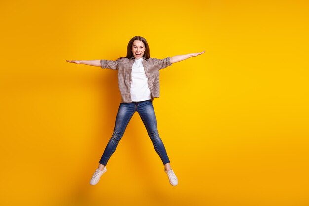 Full body photo of young pretty woman have fun jump up fly air energetic isolated over yellow color background