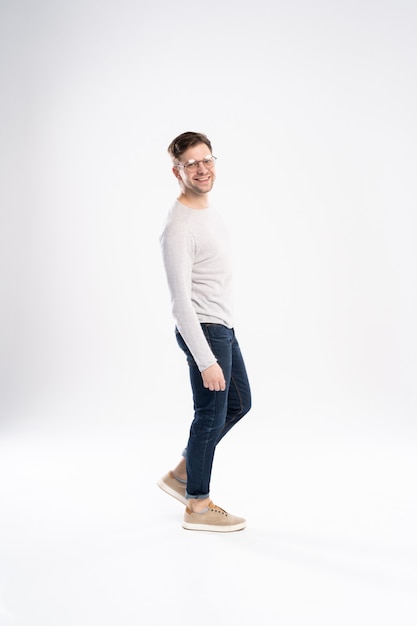 Full body picture of a smiling casual man standing on white