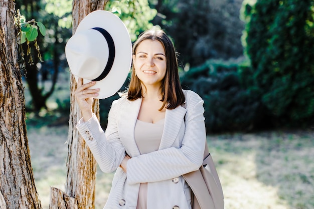 Full body portrait of caucasian confident business woman in suit walking in park