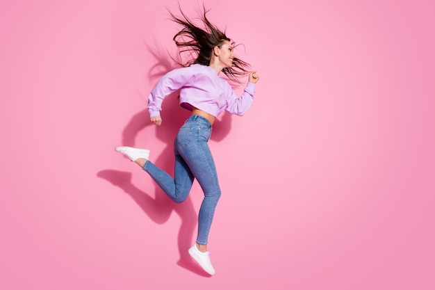 Full body profile side photo of cheerful girl jump run copyspace hurry season discounts wear style trendy pullover isolated over pastel color background