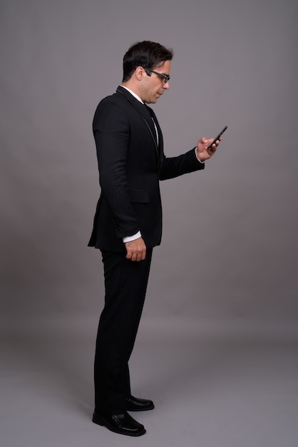 Full body shot of handsome businessman using phone