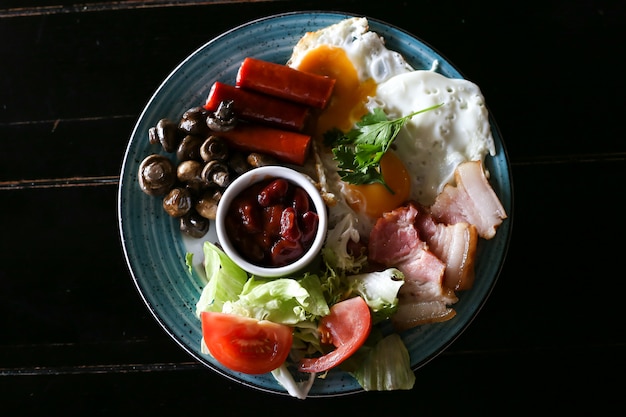 Full English cooked breakfast with bacon, sausage, fried egg and baked beans