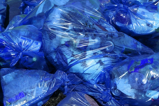 Full frame background of blue plastic trash bags with generic domestic waste