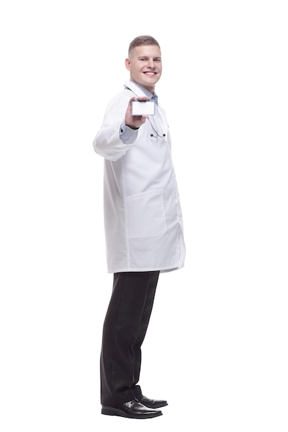 In full growth. smiling doctor showing his visiting card. isolated on a white background.