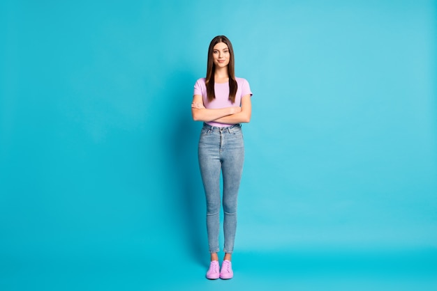 Full lenght photo of sweet charming woman wear casual violet t-shirt denim trousers arms crossed isolated blue color background