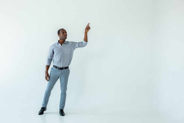 Full length of adult afro american man standing against white wall