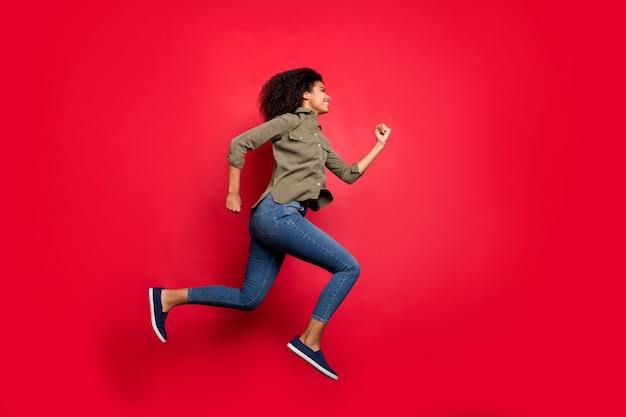 Full length body size side profile   hurrying running jumping girl wearing shirt jeans denim wearing footwear at high speed isolated