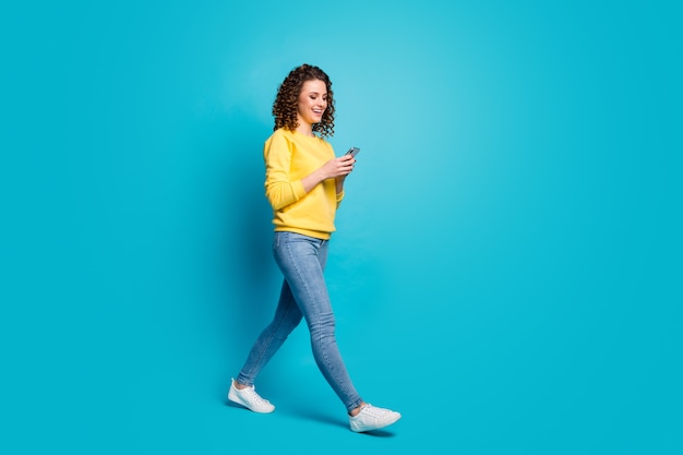 Full length body size view of girl walking using device browsing media multimedia