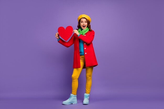 Full length body size view of nice attractive lovely foxy ginger cheerful cheery excited glad wavy-haired girl holding in hands paper heart isolated on violet lilac purple pastel color background