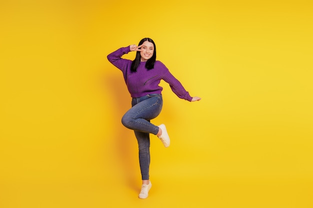 Full length body size view of nice playful girl having fun fooling show peace cool v-sign isolated on yellow color background