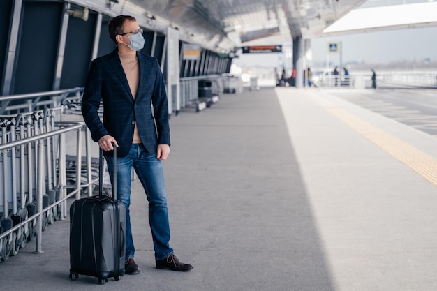 Photo full length of businessman wearing mask standing at airport