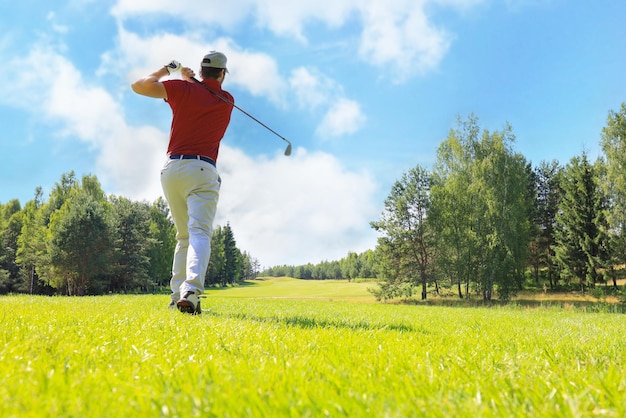 Full length of golf player playing golf on sunny day Professional male golfer taking shot on golf course