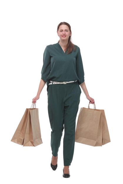 Full length of happy young woman walking with shopping bags isolated over white background