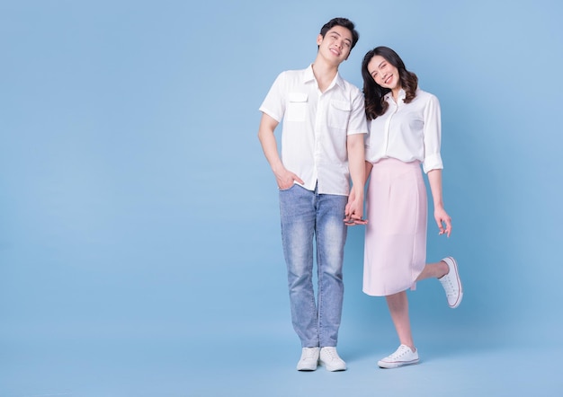 Full length image of young Asian couple on blue background