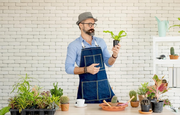 Photo full length of man standing by potted plants against wall