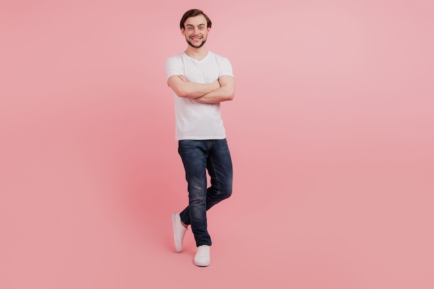 Full length photo of attractive young man happy positive smile crossed hands isolated on pink color background