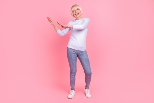 Full length photo of cheerful aged woman good mood dance wear casual clothes isolated over pink color background