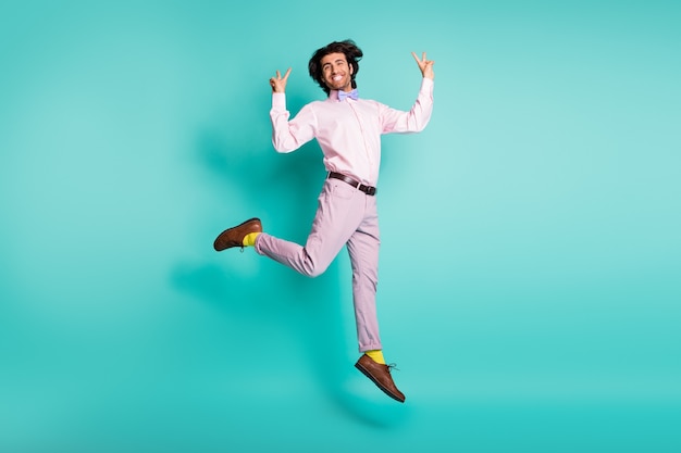 Full length photo of cool man jump show v-sign dressed formal outfit yellow socks isolated on turquoise color background