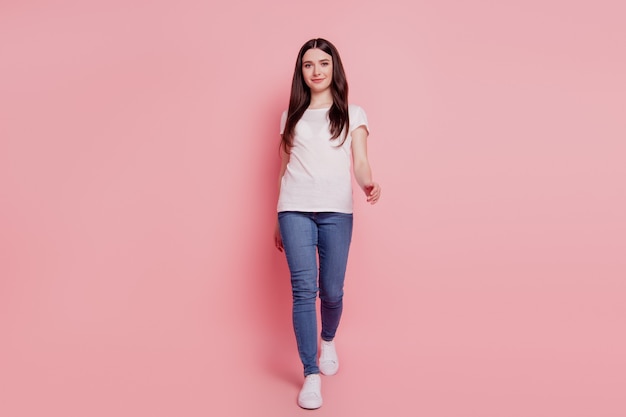 Full length photo of lovely girl happy smile go walk step wear casual style outfit isolated over pink color background