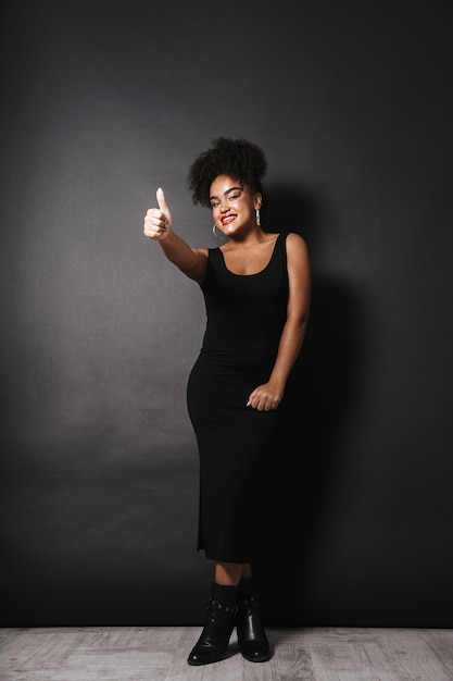 Full length photo of stylish afro american woman wearing black dress gesturing