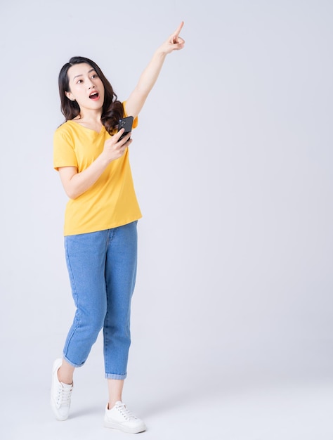 Full length photo of young Asian woman standing on white background