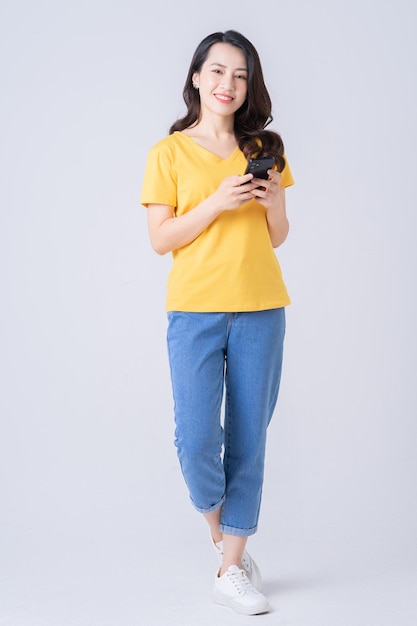 Full length photo of young Asian woman standing on white background