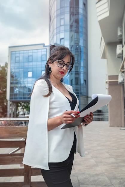 Full length photo of young attractive businesswoman outdoors in city center