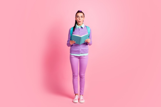 Full length photo of young woman hold diary shock wear specs rucksack purple pullover pants sneakers isolated pink color background