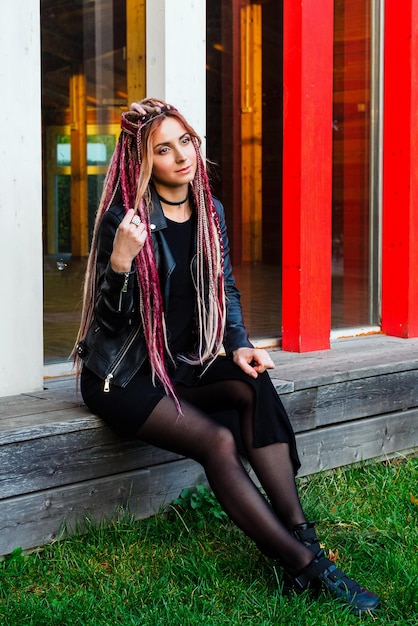 Full length portrait of a beautiful model in black clothes with hairstyle  long dreadlocks