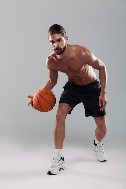 Full length portrait of a concentrated young shirtless man