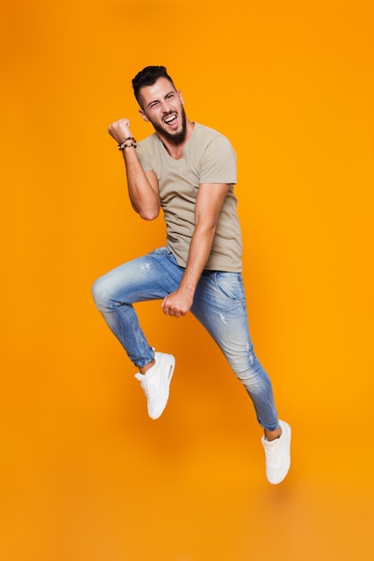 Full length portrait of an excited young casual man