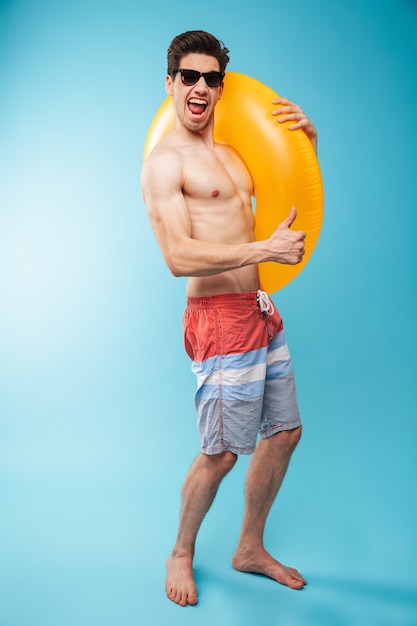 Full length portrait of an excited young shirtless man