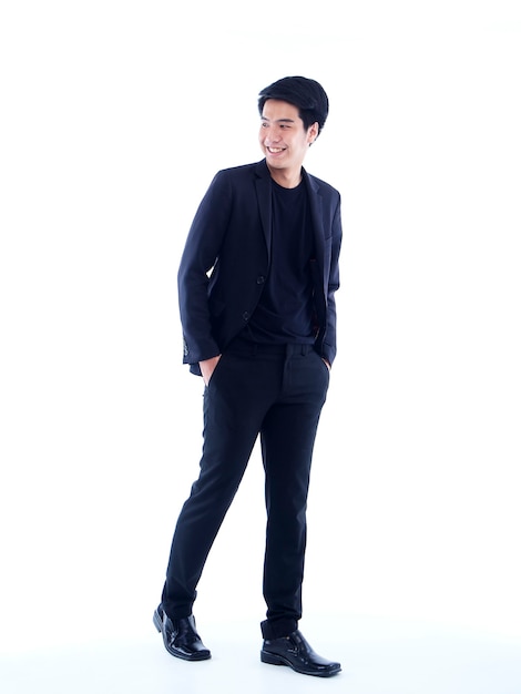 Full length portrait of handsome young man posing on white wall