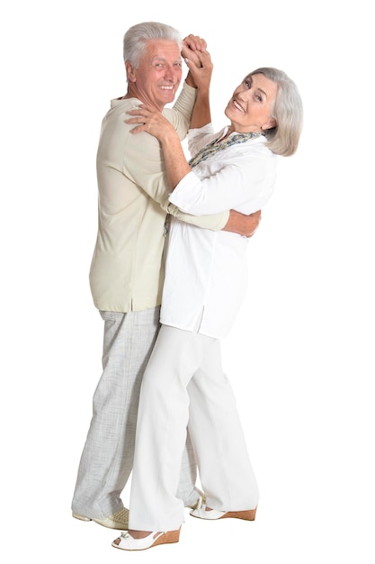 Full length portrait of senior couple dancing on white background