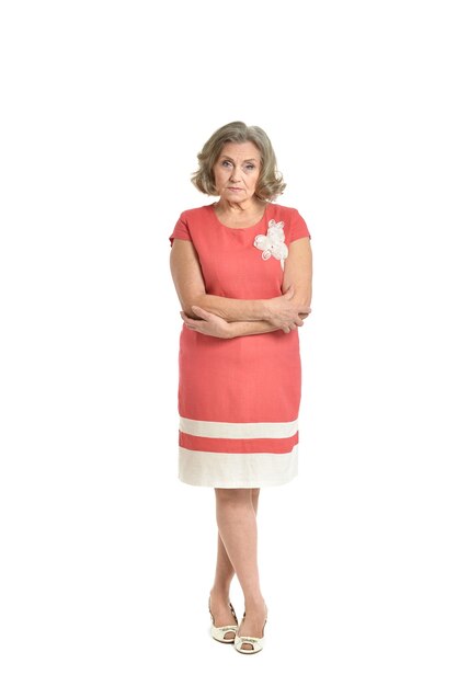 Full length portrait of senior woman in red dress on white background