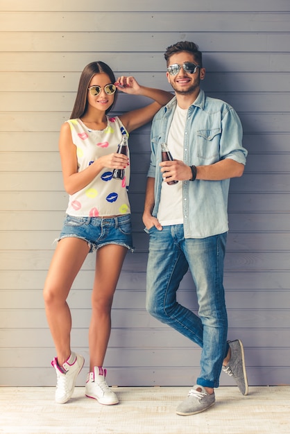 Full length portrait of teenage couple in sun glasses.