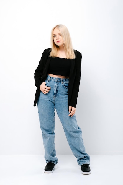 Full length portrait of teenager girl in wide jeans and black jacket