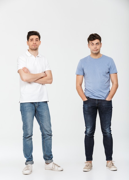 Full length portrait of two confused young men