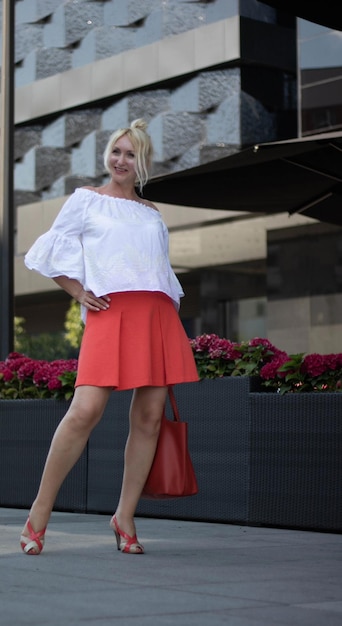 Photo full length portrait of woman standing on footpath against building