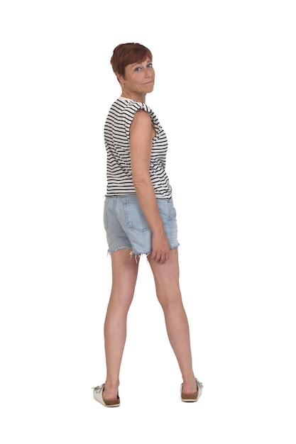 Full length portrait of a woman in summer clothes turning on white background