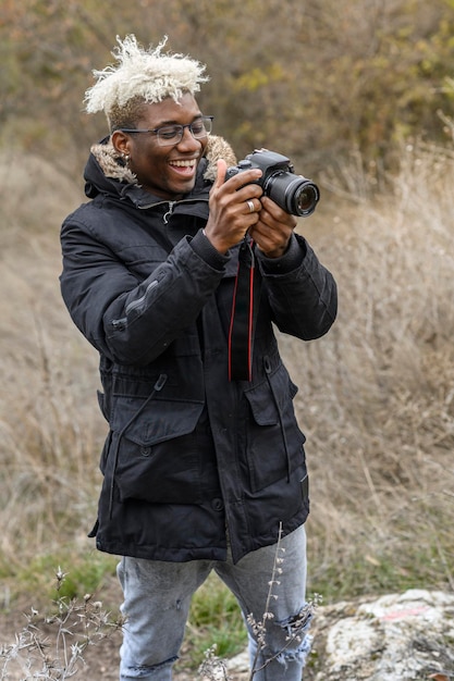 Full length portrait of young african american handsome hipster guy walks in a autumn park on the