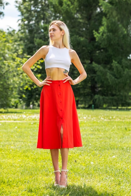 Photo full length portrait of a young beautiful girl in a long red skirt