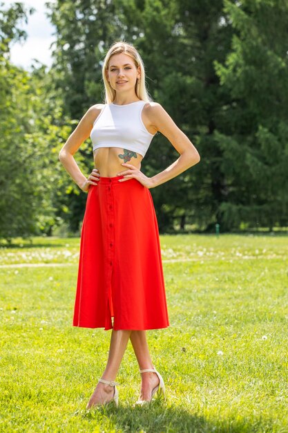 Photo full length portrait of a young beautiful girl in a long red skirt