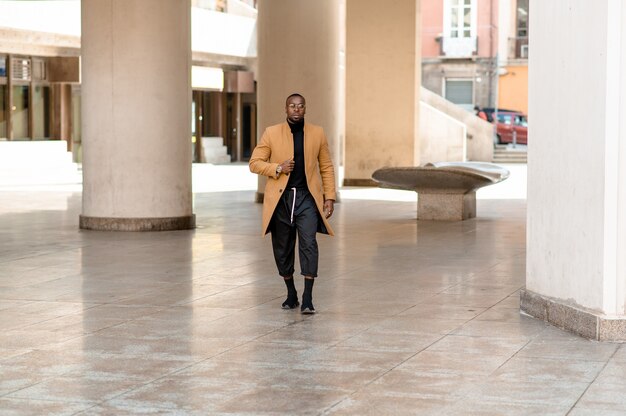 Photo full length portrait of young black businessman walking in the city.