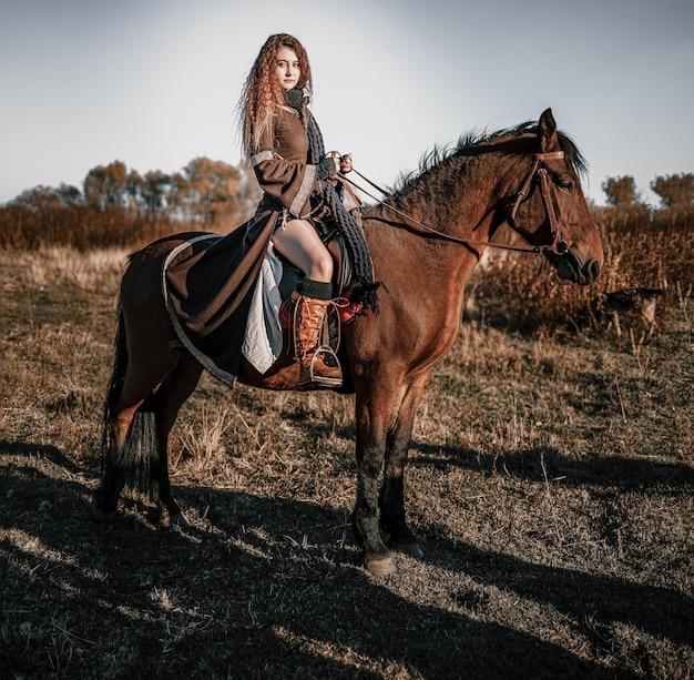 Photo full length portrait of young woman riding horse on field