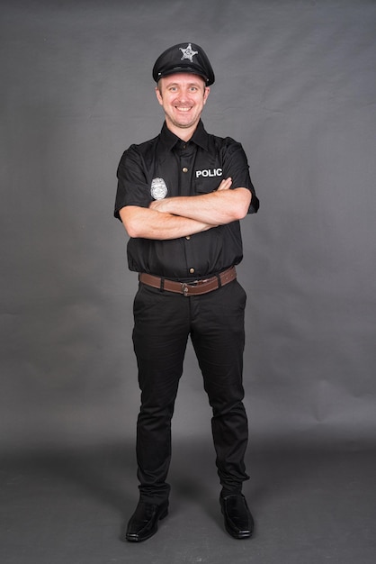 Full length shot of Caucasian man wearing police uniform costume