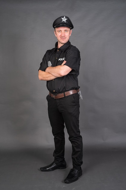 Full length shot of Caucasian man wearing police uniform costume