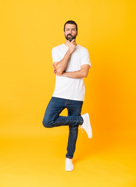 Full-length shot of man with beard over isolated yellow