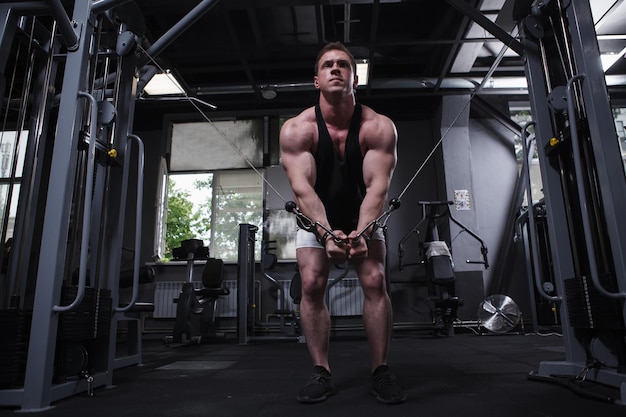 Full length shot of a muscular sportsman doing chest muscles workout at the gym