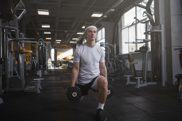 Full length shot of a sportsman doing weighted lunges with dumbbells